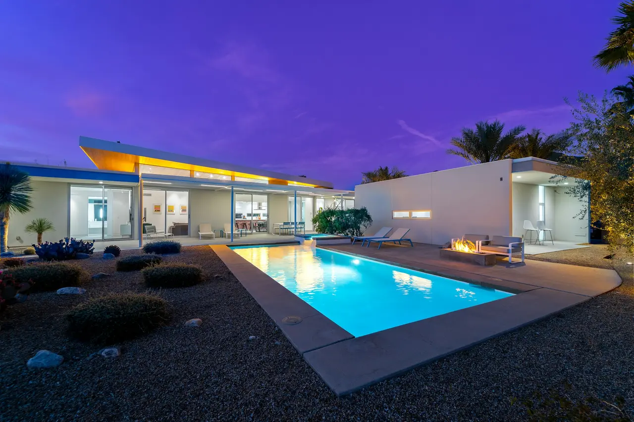 Lit swimming pool at a modern desert home at twilight